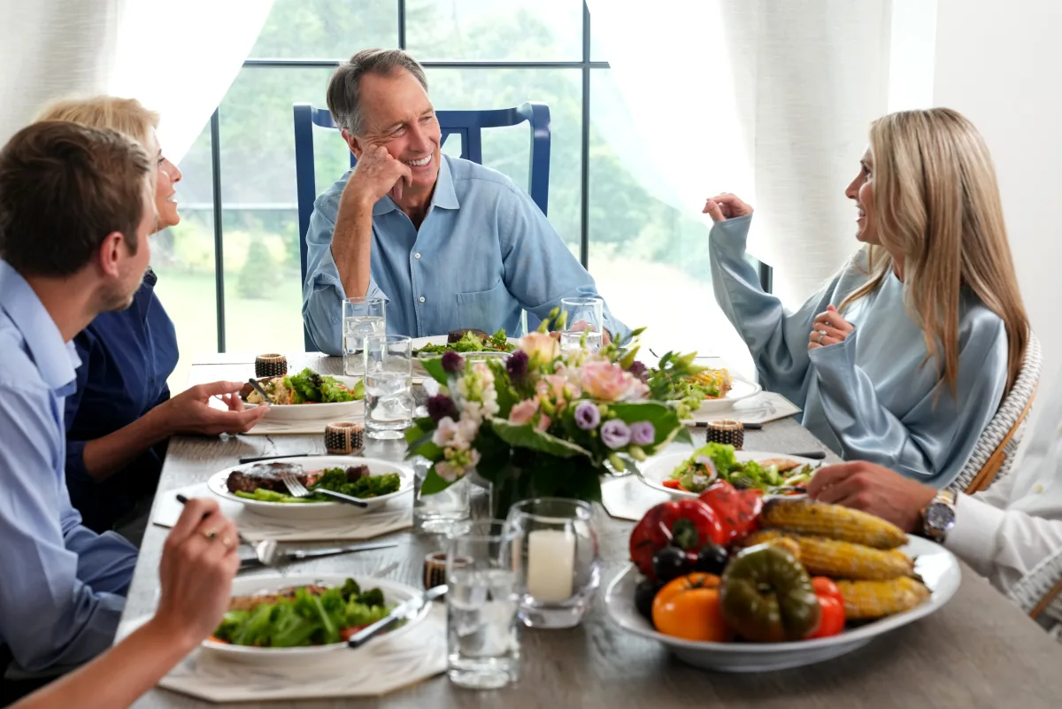 Friends laughing over a table of fresh food
