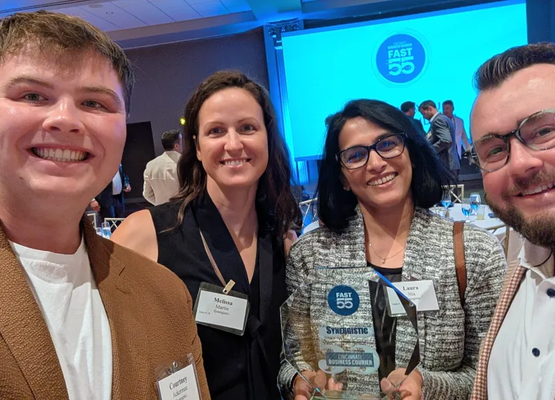 Four teammates with an award at an industry event