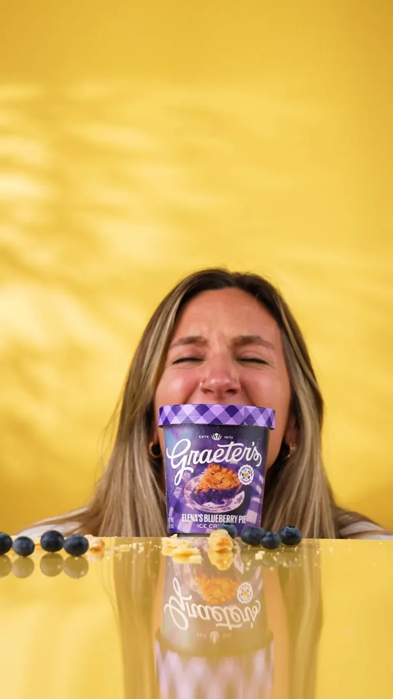 A teammate celebrating with a pint of Graeter's ice cream on a yellow set